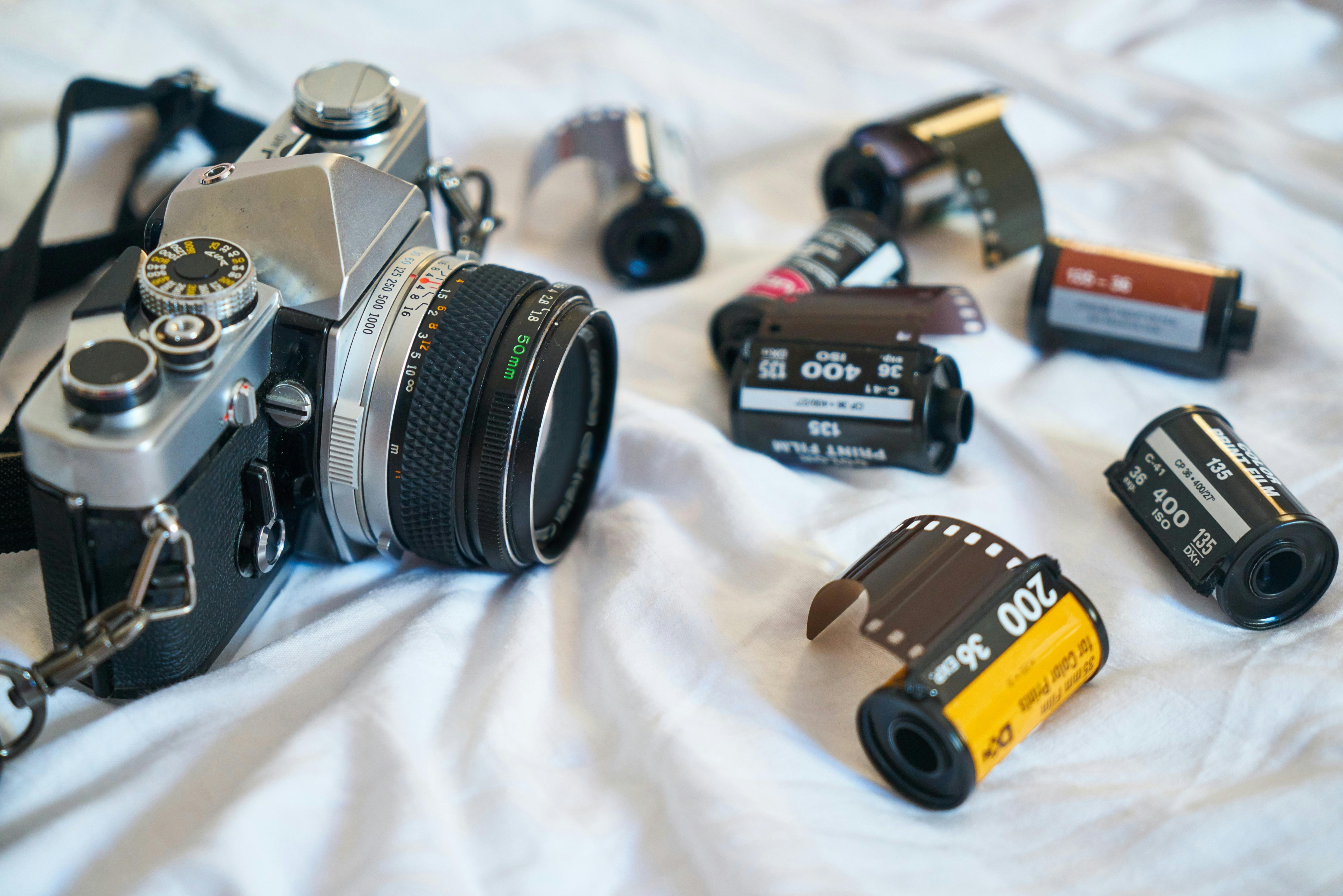 A classic film camera surrounded by various film rolls, evoking a retro photography vibe.